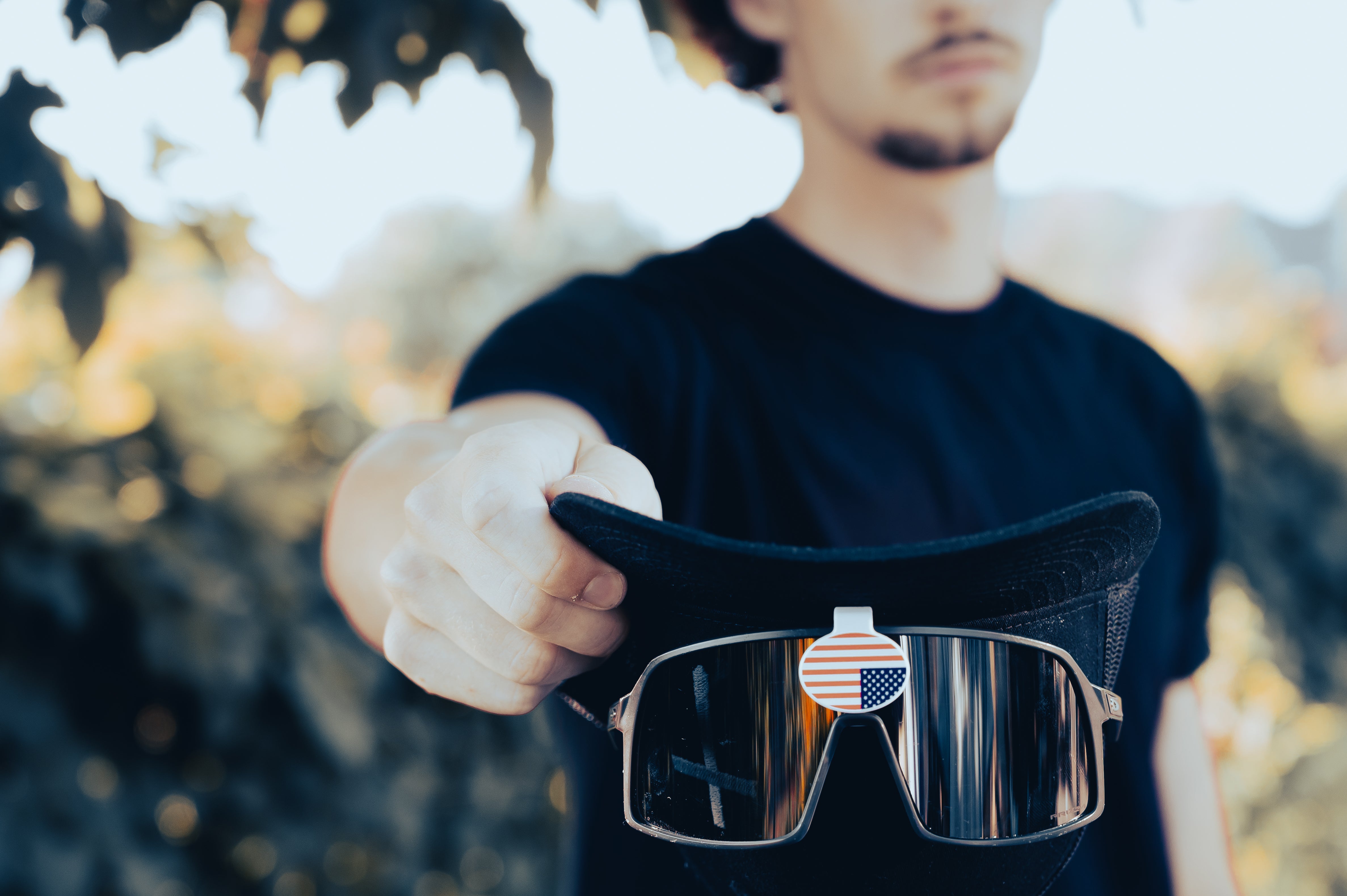 LiDGiT model holding a hat upside down with glasses on showing the functionality of the product.